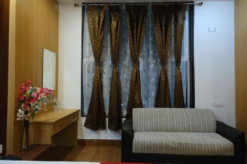 a living room with a couch and a window at Hotel Golden Continental in Deoghar