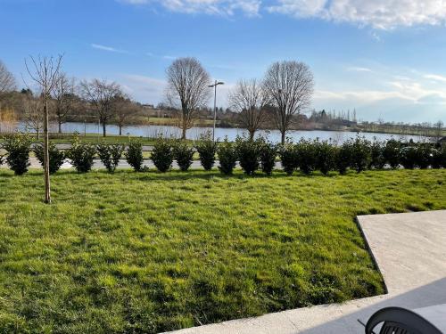 Une rangée d'arbres dans un parc à côté d'un lac dans l'établissement Résidence du lac, à Bourbon-Lancy