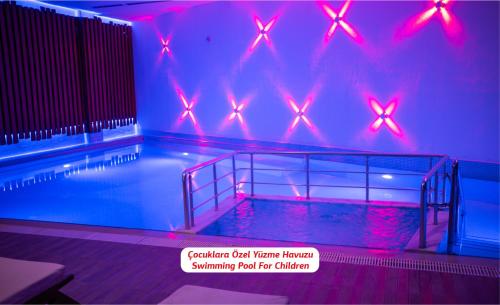 a swimming pool with red lights in a room at Yalova Lova Hotel & SPA Yalova in Yalova