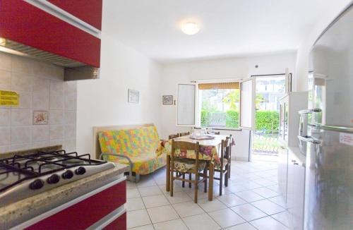 a kitchen with a stove and a table with a chair at Apartment in San Michele al Tagliamento 45669 in San Michele al Tagliamento