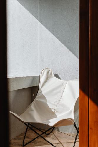 a white chair sitting next to a wall at THE MODERNIST, Architecture experience in Faro