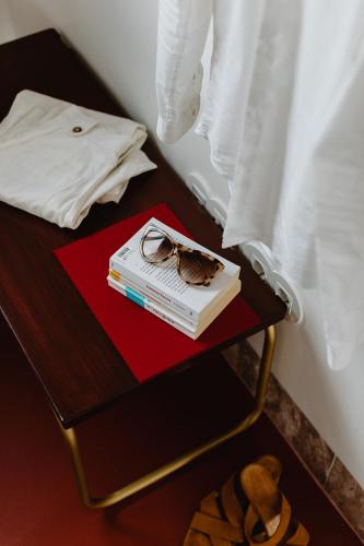 a book and glasses on a table next to a bed at THE MODERNIST, Architecture experience in Faro