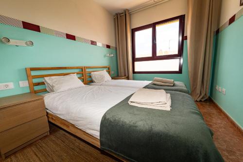 een slaapkamer met een groot bed en een raam bij Casa Carola - Bahia Sol in Caleta De Fuste