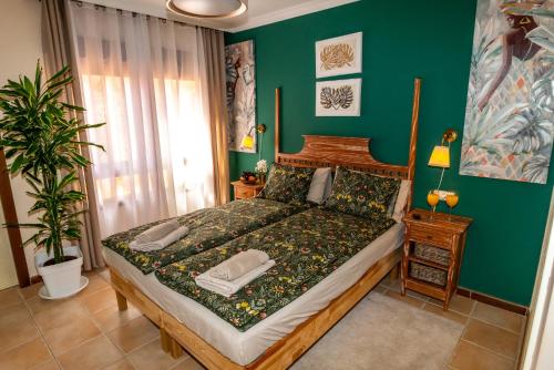 a bedroom with a bed and a green wall at Villa V8 in Caleta De Fuste