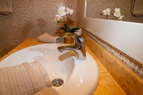 a bathroom sink with a faucet and a mirror at Villa V8 in Caleta De Fuste