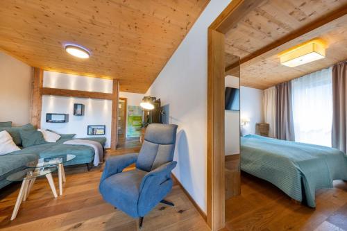 a bedroom with two beds and a blue chair at Residenz Wildkogelbahnen Top 20 in Neukirchen am Großvenediger