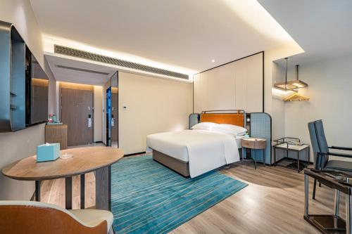 a hotel room with a bed and a table at Echarm Hotel Huizhou Boluo Yuanzhou Store in Yuanzhou