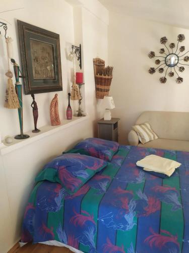 a bedroom with a bed with a colorful comforter at Studio confortable à Veyras avec jardin et piscine in Veyras