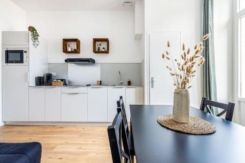 - une cuisine et une salle à manger avec une table et un vase dans l'établissement Appartement centre ville idéal cures proche gare, à Aix-les-Bains