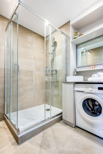 une salle de bain avec une machine à laver et un lave-linge dans l'établissement Appartement centre ville idéal cures proche gare, à Aix-les-Bains