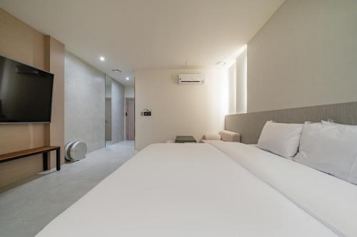a bedroom with a large bed and a flat screen tv at Hotel THE ART UIWANG in Uiwang