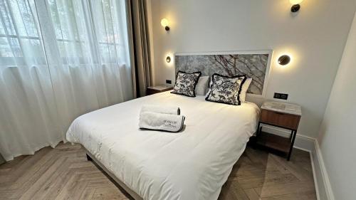 a bedroom with a large white bed with two pillows at Gite du manoir des perrieres in Rochechouart
