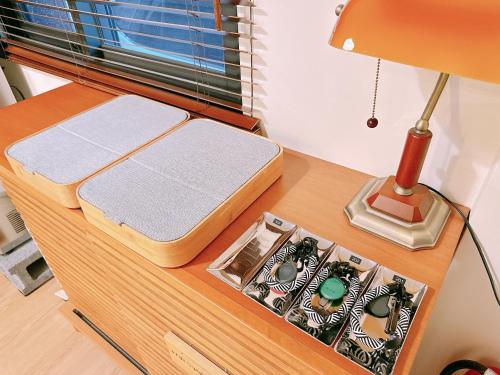 a table with a lamp and a box on it at Gardenstay in Luodong