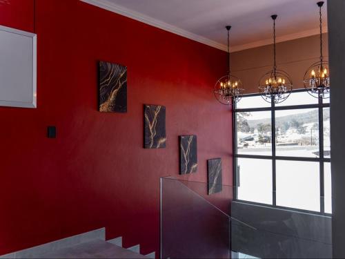 a room with red walls and a staircase with paintings at The Hill Boutique Hotel in Tsolo