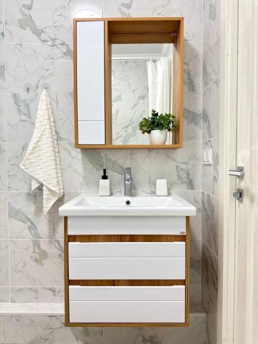 a bathroom with a sink and a mirror at Easy Apart in Taldykolʼ