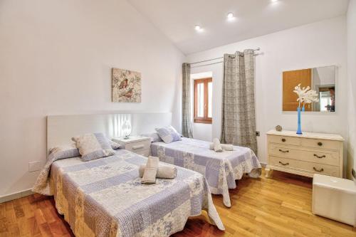 a bedroom with two beds and a dresser at Ca Se Predine by Rentallorca in Alcudia