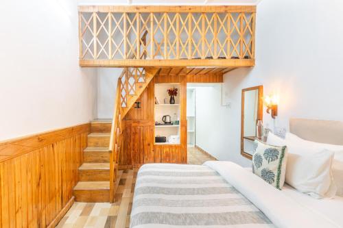 a bedroom with a bed and a stairway at House of Hive, Mukteshwar in Mukteswar