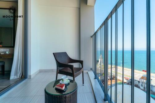 a balcony with a chair and a view of the ocean at Moonlight Bay Panorama Condotel Ocean View in Nha Trang