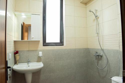 a bathroom with a shower and a sink and a sink at Слънчевите Къщи-село Китка in Kitka