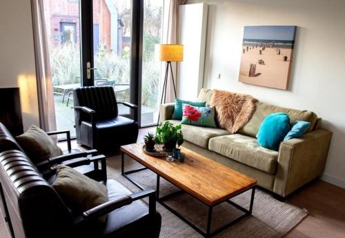 a living room with a couch and a coffee table at Villa Duinroos in Egmond aan den Hoef