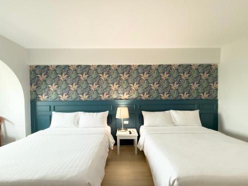 two beds sitting next to each other in a room at Regent Ramkhamhaeng 22 in Bangkok