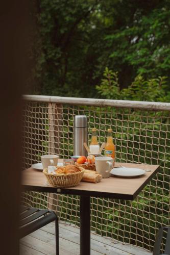 een tafel met een mand brood en drankjes erop bij La Batelière sur Loire in La Chapelle-aux-Naux
