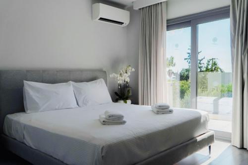 a bedroom with a bed with two towels on it at Princess Sun Hotel in Kiotari