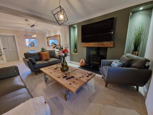 a living room with couches and a coffee table at Stylish and Modern 7 Bedroom house near Brecon Beacons in Cefn-coed-y-cymmer