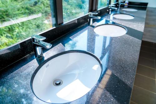 a bathroom sink with three sinks on a counter at LiLa Inn & Motorbike Tours Ha Giang in Ha Giang