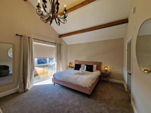 ein Schlafzimmer mit einem Bett und einem großen Fenster in der Unterkunft Stylish and Modern 7 Bedroom house near Brecon Beacons in Cefn-coed-y-cymmer
