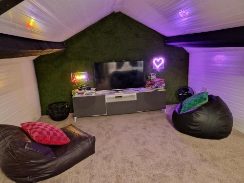 a living room with a tv and two couches at Stylish and Modern 7 Bedroom house near Brecon Beacons in Cefn-coed-y-cymmer