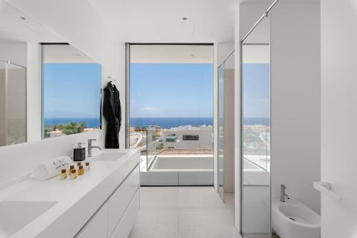 a white bathroom with a view of the ocean at Karat Villa Murano in Callao Salvaje