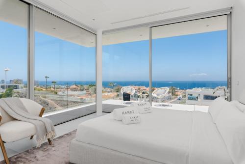 a bedroom with a white bed and a large window at Karat Villa Murano in Callao Salvaje