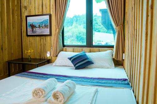 a bedroom with two beds and a window at LiLa Inn & Motorbike Tours Ha Giang in Ha Giang