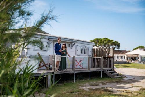 a man and a woman standing on a bridge in front of a house at Lodge Sainte Helene Adult only in Saintes-Maries-de-la-Mer