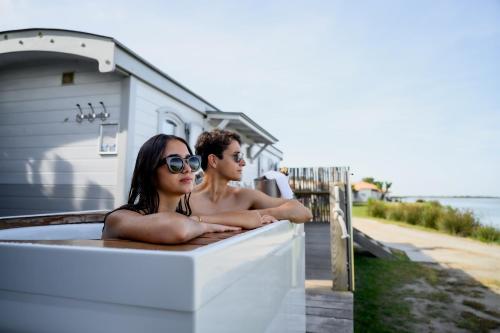 a man and a woman sitting in a bath tub at Lodge Sainte Helene Adult only in Saintes-Maries-de-la-Mer