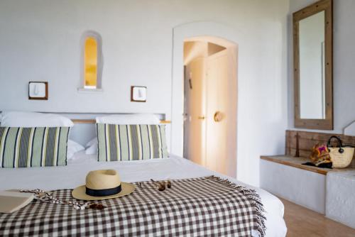 a bedroom with a bed with a hat on it at Lodge Sainte Helene Adult only in Saintes-Maries-de-la-Mer