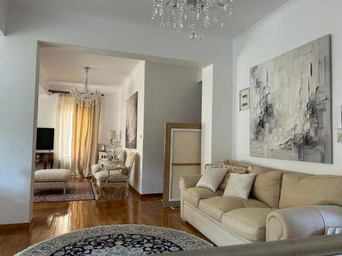a living room with a couch and a chandelier at Oikia Apozari Megalos Filippos in Kastoria