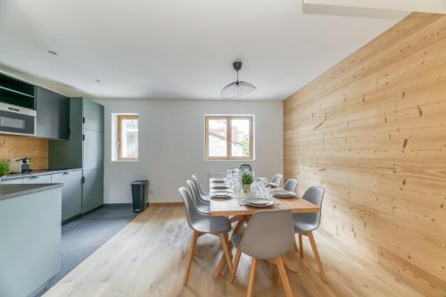 - une salle à manger avec un mur en bois, une table et des chaises dans l'établissement PicBlanc - Duplex - Chaleureux - Balcon, au Bourg-dʼOisans