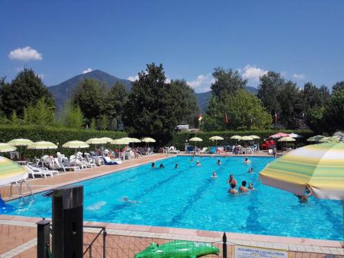 a large swimming pool with people in the water at Camping-Village del Sole in Cannobio