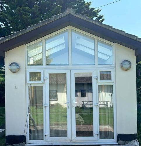a conservatory with glass doors on a house at #1 Stoneleigh Cottage in Seaton