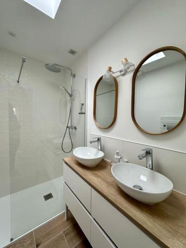 une salle de bain blanche avec deux lavabos et une douche dans l'établissement Port-Manech', Maison avec piscine - Plages à pied, à Kermen