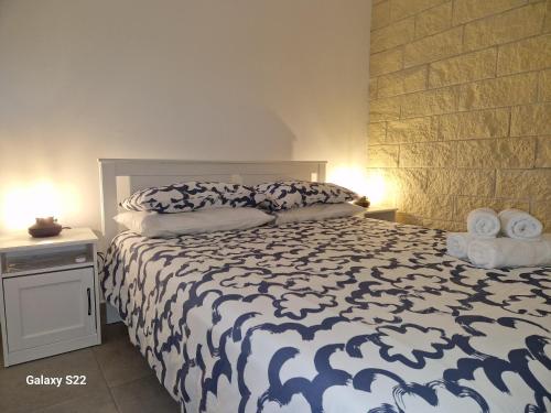 a bedroom with a bed with a blue and white comforter at Ta' Marie Bed and Breakfast in Chiaramonte Gulfi