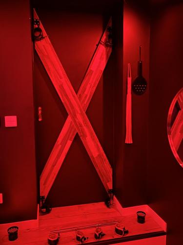 une chambre rouge avec un x en bois sur le mur dans l'établissement Love room in Paris, à Paris