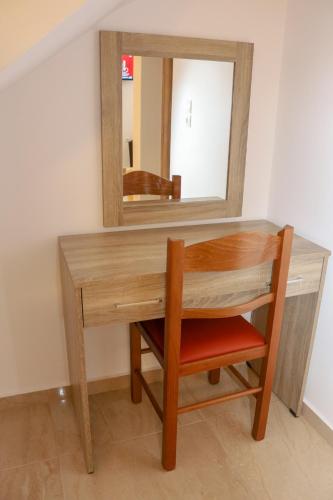 a wooden desk with a mirror and a chair at ALTAVILLAS maisonettes in Kakí Vígla