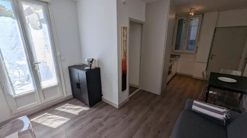 - un salon avec une armoire noire et une fenêtre dans l'établissement Les Trois Mai, à Cannes