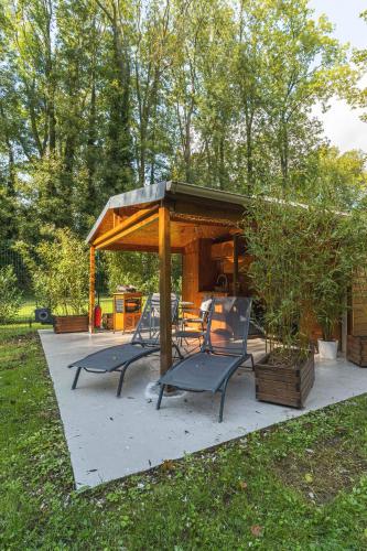 a gazebo with two chairs and a table at Chalet au Coeur de Foret Gouvieux in Gouvieux