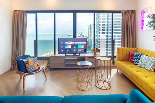 a living room with a yellow couch and a large window at Sunrise Gurney in George Town