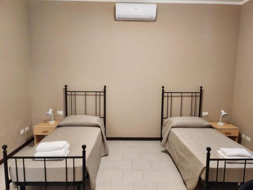 two beds in a room with two night stands at Il mulino foresteria in Parona