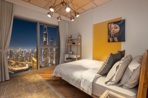 a bedroom with a bed with a view of a city at Exclusive front row seats to Burj Khalifa fireworks from penthouse level, downtown Dubai in Dubai